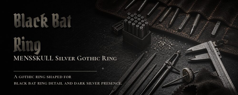 sculpted black bat ring in a dark jewelry workshop
