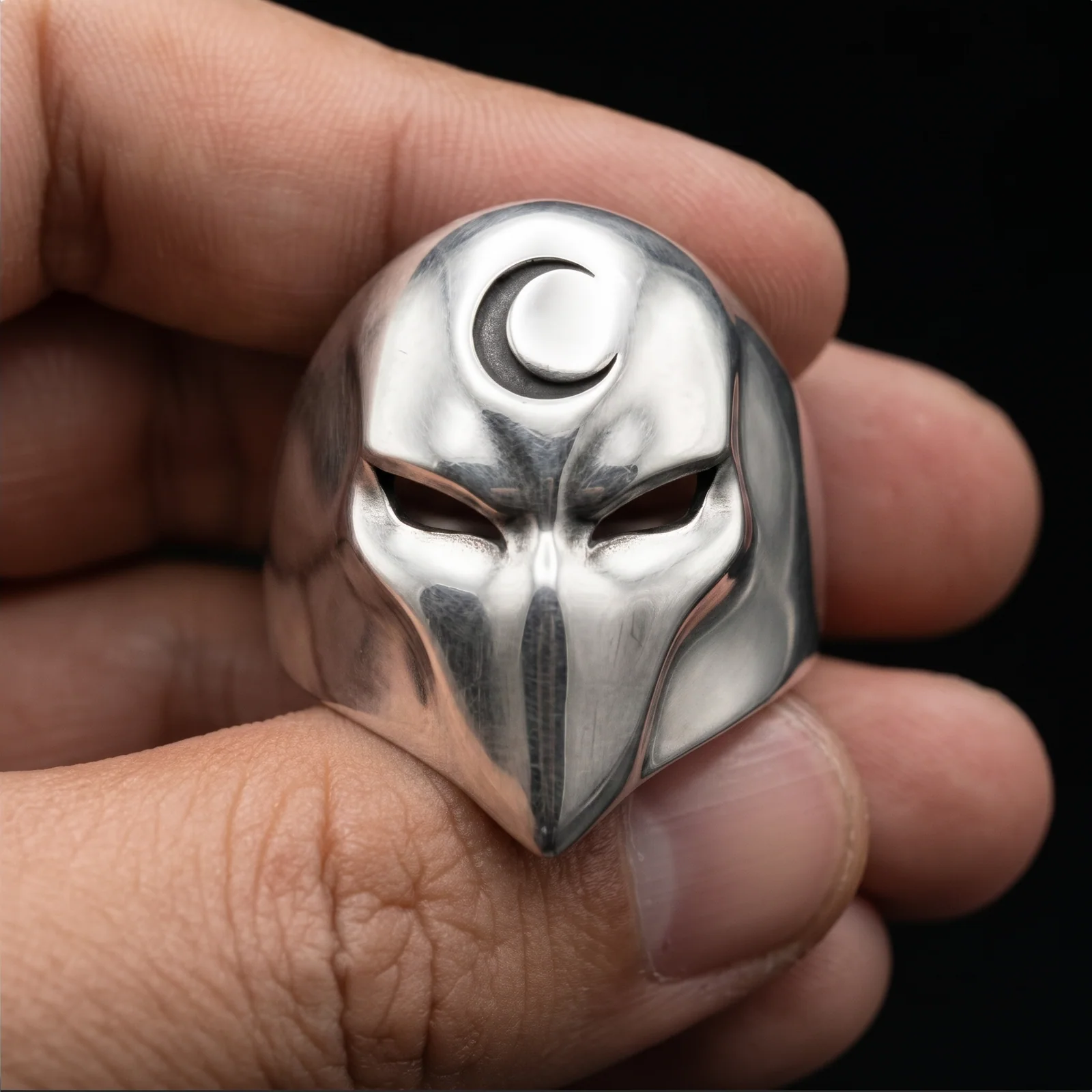 Crescent moon phantom face ring held in a centered front view for detail
