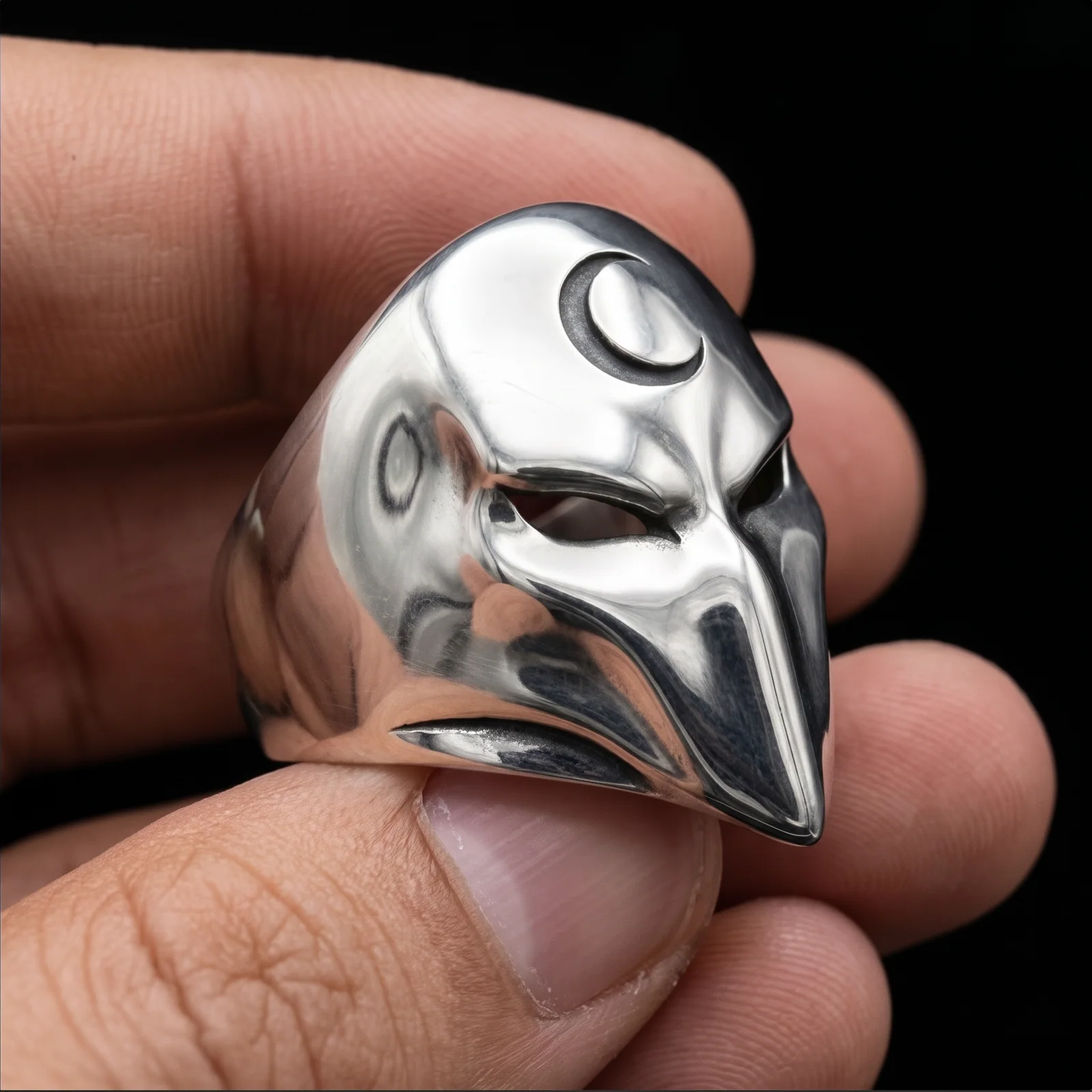925 sterling silver mask ring held from the right side to show its curved shoulder and eye opening