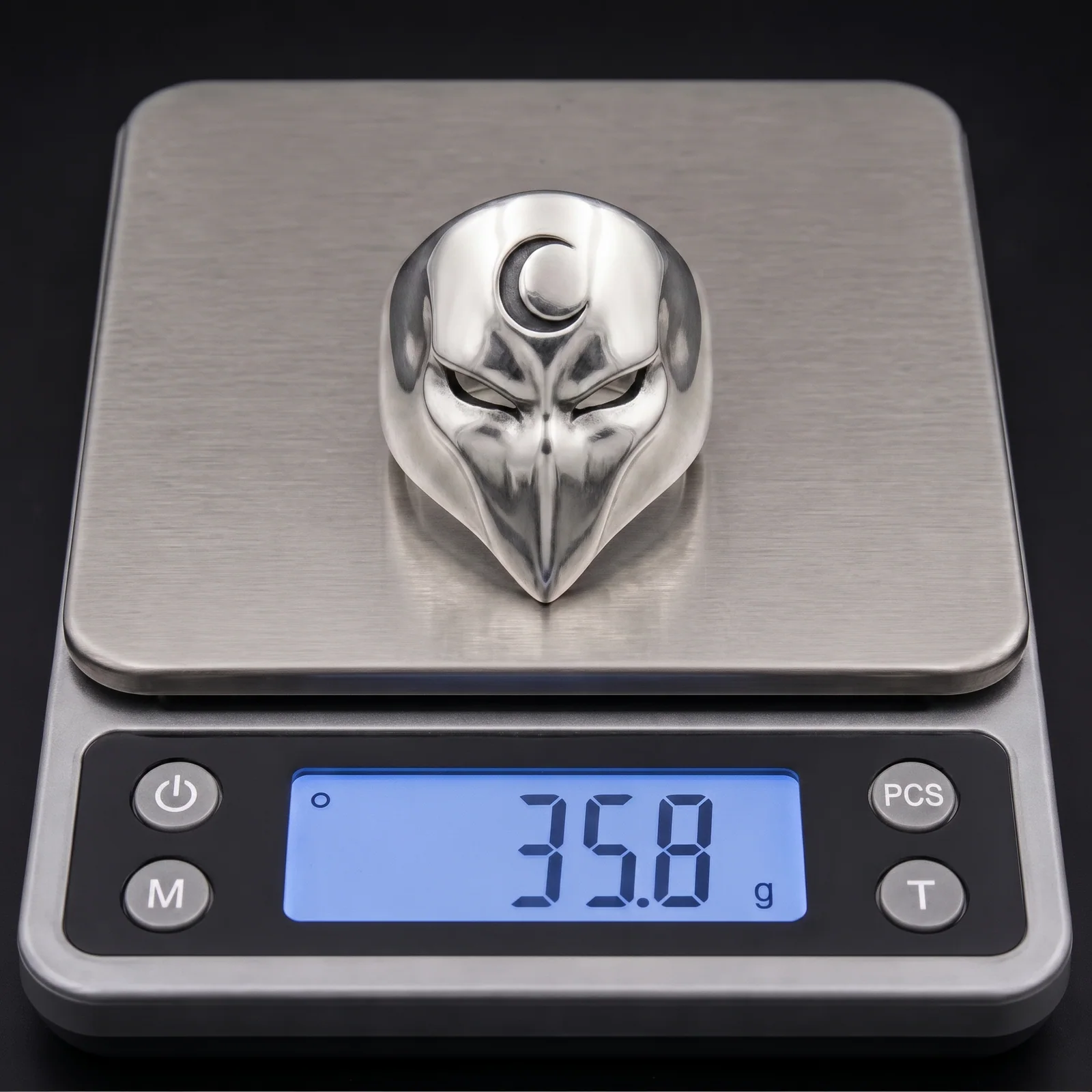 One crescent moon mask ring sample on a digital scale as a weight reference