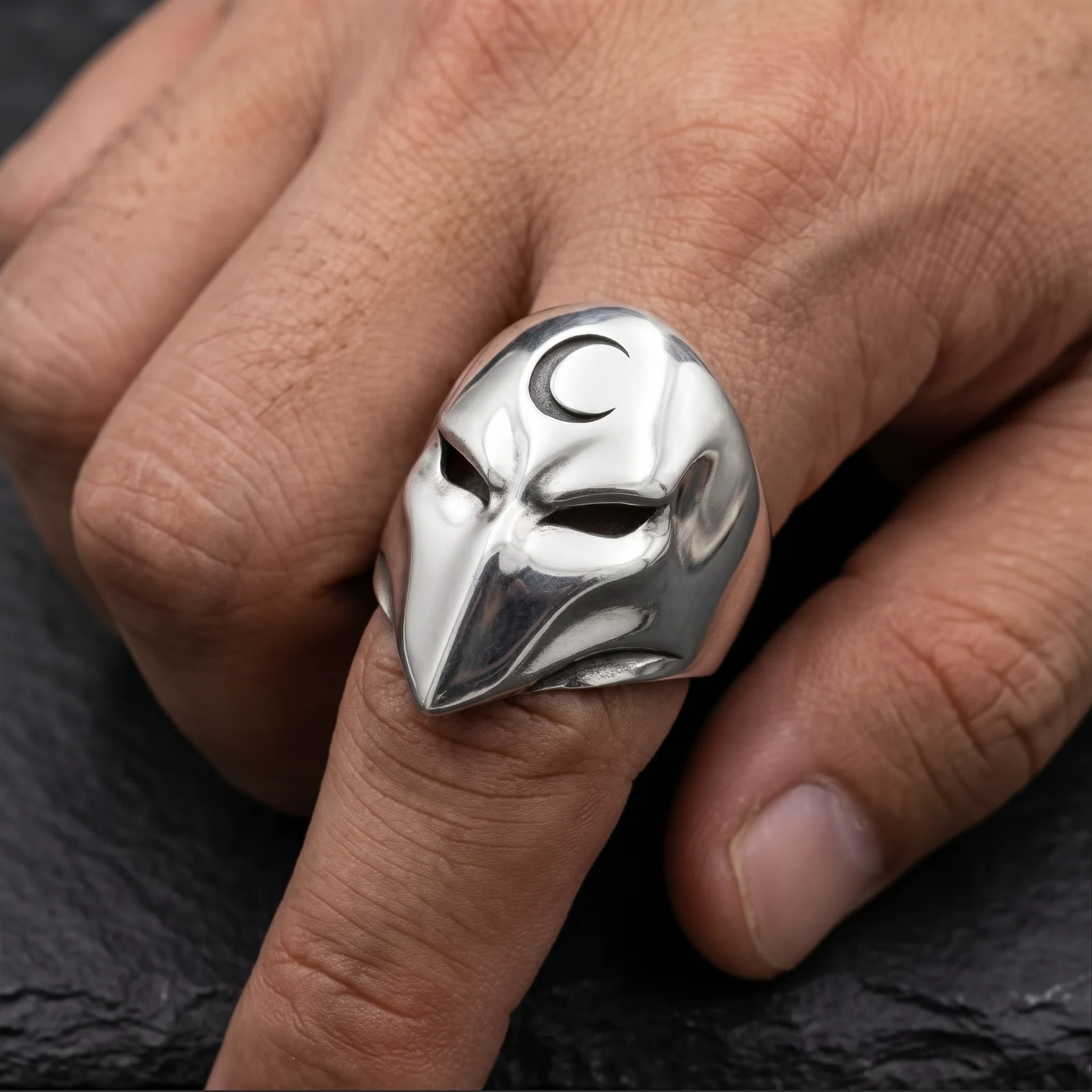 Polished phantom mask ring worn close up with the crescent forehead detail visible