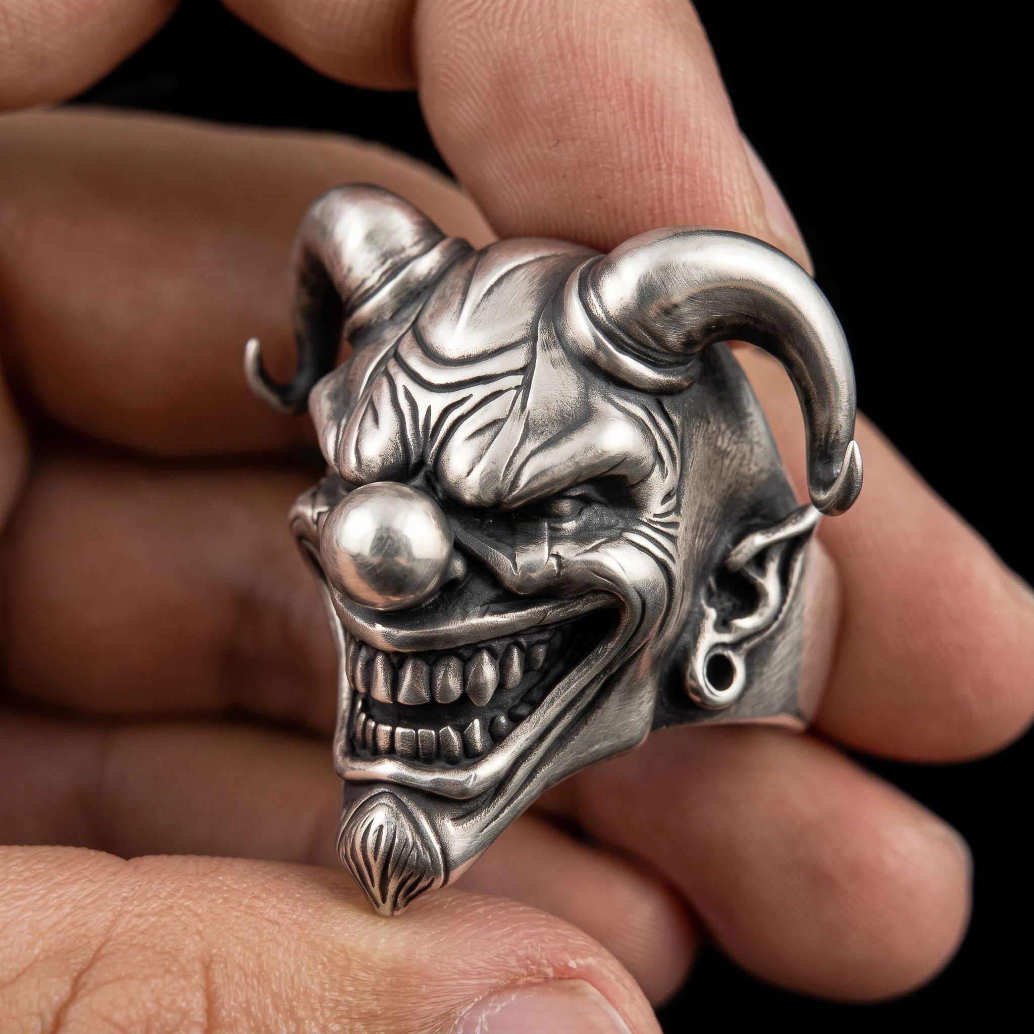Heavy jester ring held at an angle showing the right curled horn