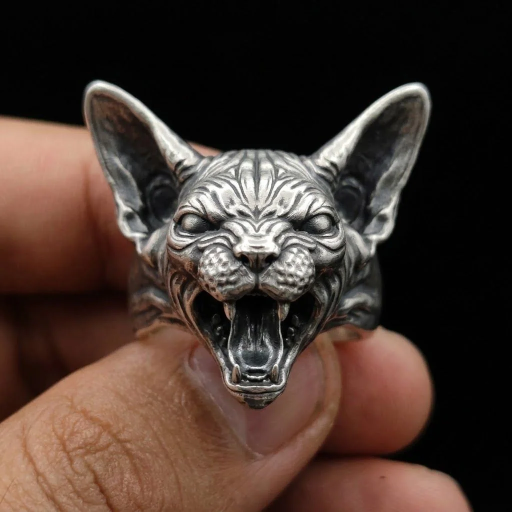 Open-mouth Sphynx cat ring held in a centered front view for detail
