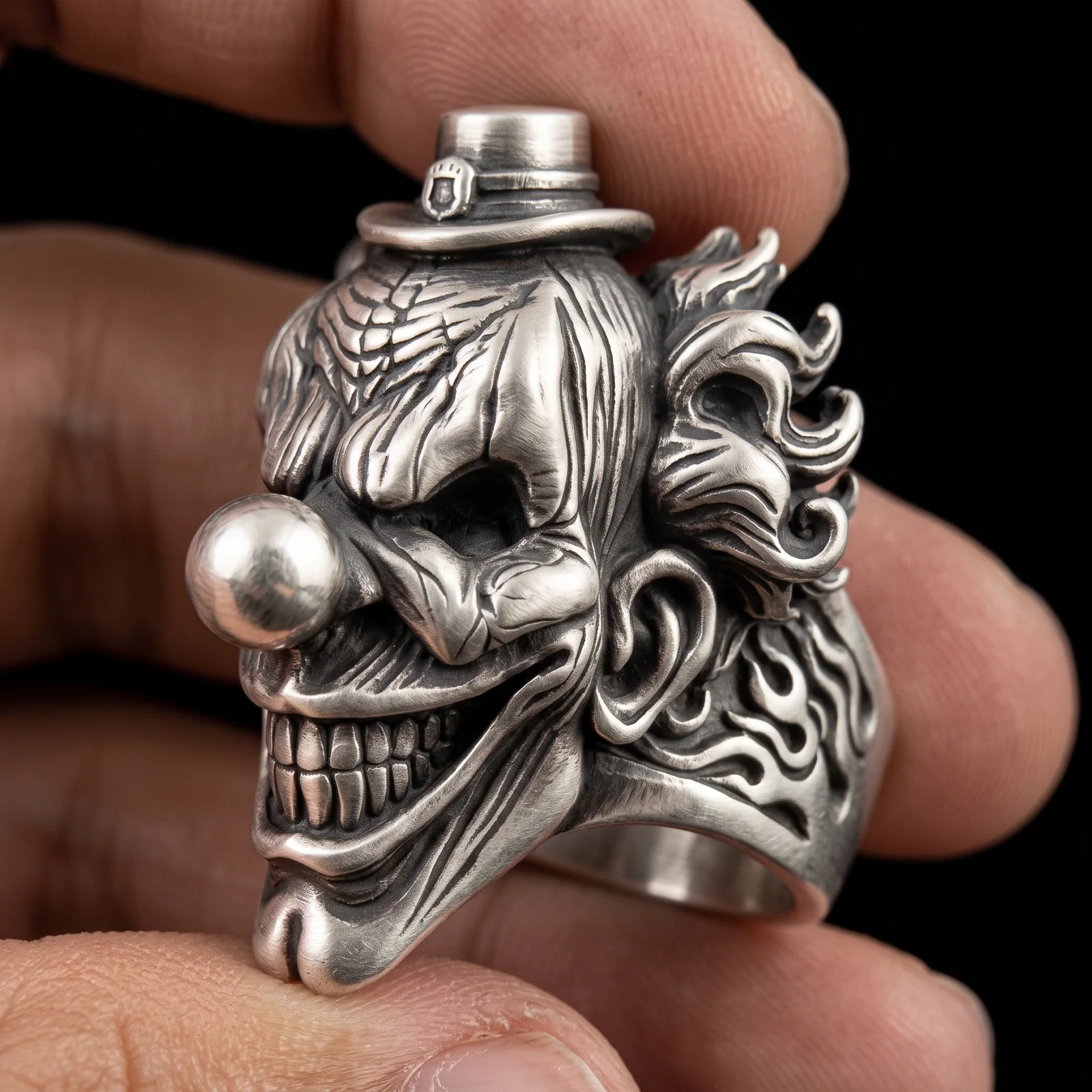 Gothic clown ring side view showing raised flame hair scrollwork and open band interior