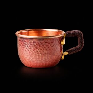 Hand-hammered red-copper mini cup with cord-wrapped angular handle on black
